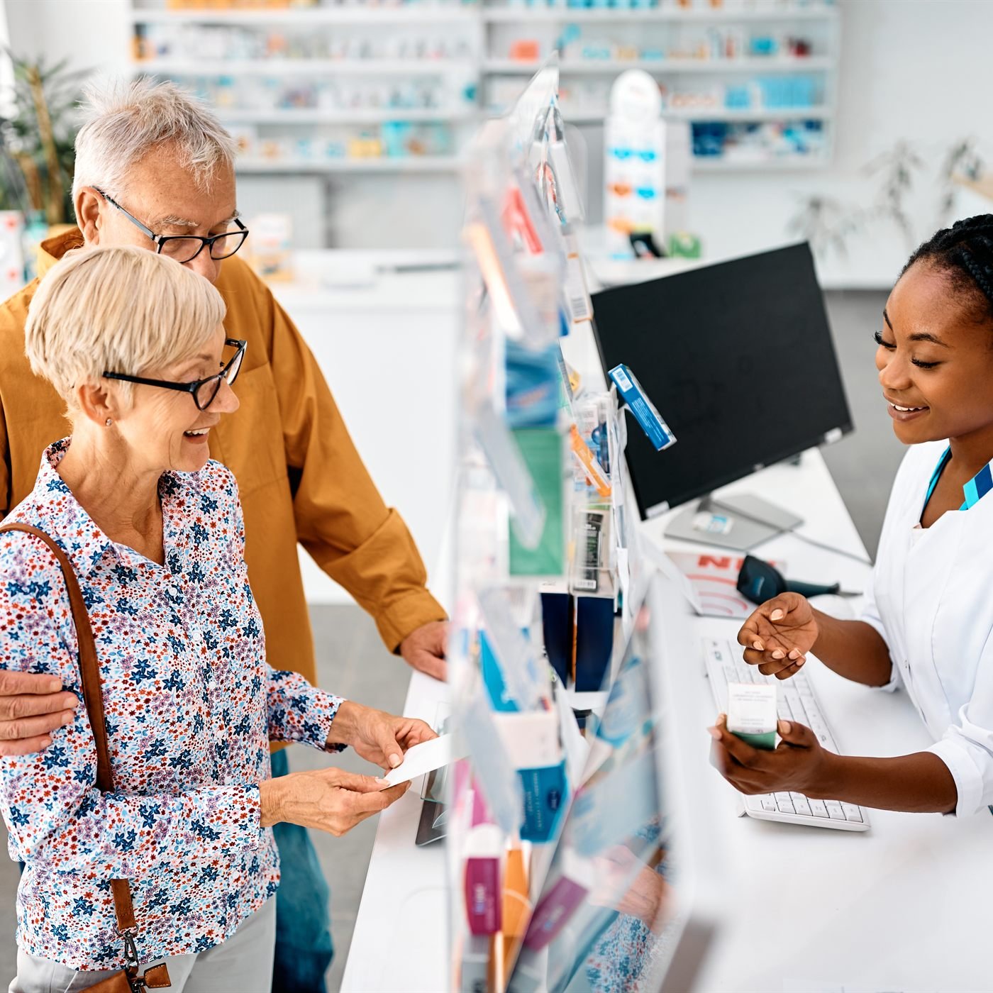A senior couple speaking with a pharmacist about prescription medicine